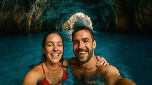 Honeymoon couple taking a selfie inside of the Blue Cave in Montenegro
